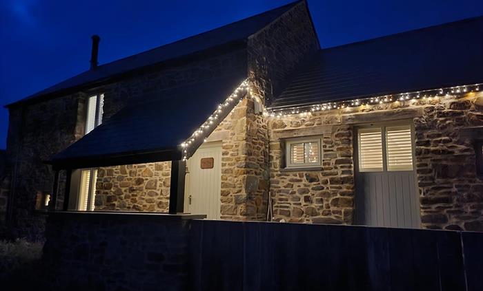 The Mill House looking warm and welcoming with outside fairy lights on in winter.
